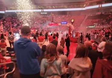 A crowd of people in an arena with lights.